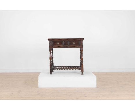 A Charles II oak side table, late 17th century, the moulded rectangular top above a frieze, set with a pair of short frieze d