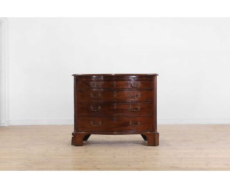 A George III mahogany serpentine chest of drawers, c.1770, with a brushing slide above four graduated drawers set between flu