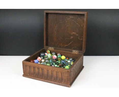 Oak carved wooden box containing a large collection of glass marbles, box measures 15cm wide