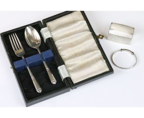 A small collection of hallmarked sterling silver to include a cased fork and spoon set, napkin ring and a christening bangles