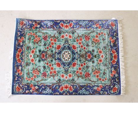 20th century Iranian silk turquoise ground prayer mat, central medallion within flowering scrolls and blue border, 76 x 55cm