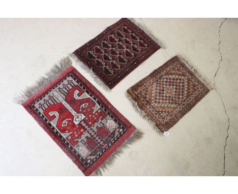 Red ground prayer mat with geometric design, 74 x 60.5cm and two other prayer mats (3)