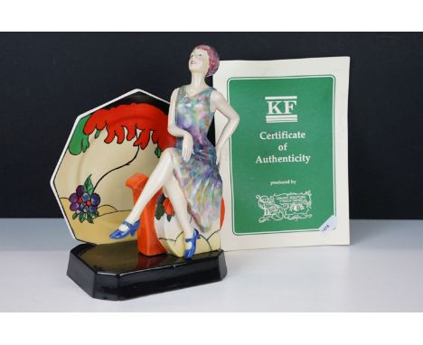'Tea with Clarice Cliff' figurine sculpture with Clarice Cliff seated on an Art Deco tea pot against the backdrop of a plate,