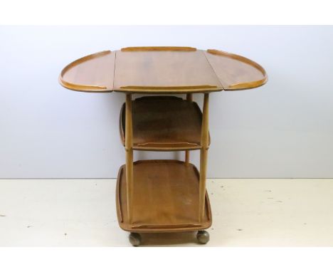 Ercol elm three-tier hostess trolley, the top with two drop leaves, on casters, 76cm high x 95cm wide (extended) x 73cm deep