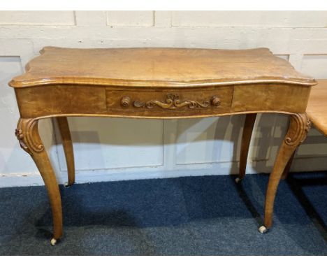 A Louis XV style satinwood side table with serpentine shaped top, single centre drawer, on scroll carved cabriole legs and ce