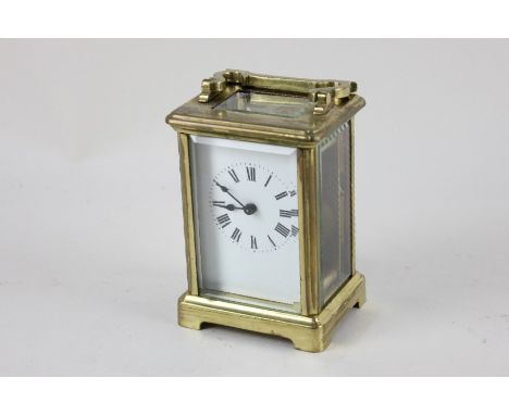 A brass and bevelled glass cased carriage clock, the dial with Roman numerals, with key, 11.5cm high (a/f)