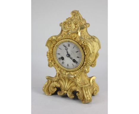 A 19th century French Rococo style gilt metal mantle clock, with eight day movement, the circular silvered dial with Roman nu