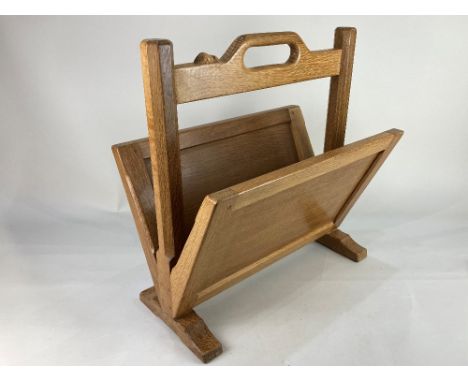 A Robert Mouseman Thompson oak magazine rack sloping panel sides and central octagonal supports with carry handle, carved mou