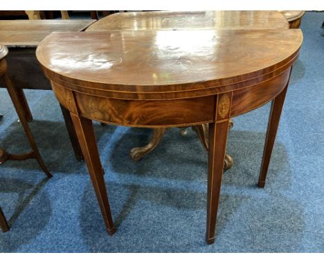 An Edwardian Sheraton style mahogany demi lune card table crossbanded foldover top with green baise lining, inlaid line edges