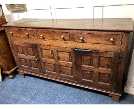 A George III oak dresser three drawers with brass knob handles, above two panelled cupboards, on bracket feet, 162cm