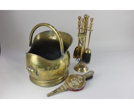 A brass coal scuttle, a set of four brass fire tools, and a small pair of bellows decorated with a clipper sailing ship