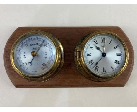 A Sestrel brass cased bulkhead barometer and alarm clock on wooden mount, 23.5cm wide