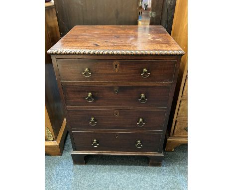 A George III mahogany small chest of drawers top with carved gadrooned border, brass loop handles and side carry handles, on 