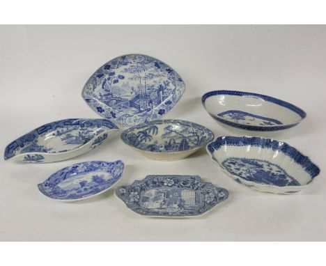 A quantity of various early 19th century blue and white navette shaped dishes, and stands, decorated with transfer prints, Do