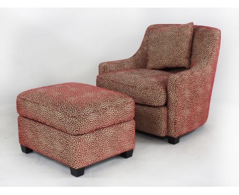 A contemporary cream and red upholstered armchair, and matching pouffe