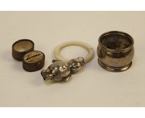 A silver and mother of pearl teething ring, in the form of a Kewpie baby, together with a napkin ring and a gold plated ring