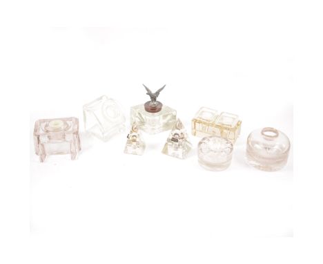 Fifteen glass inkwells, various shapes and designs, one with a metal cover having an eagle surmount, two double inkwells, a h
