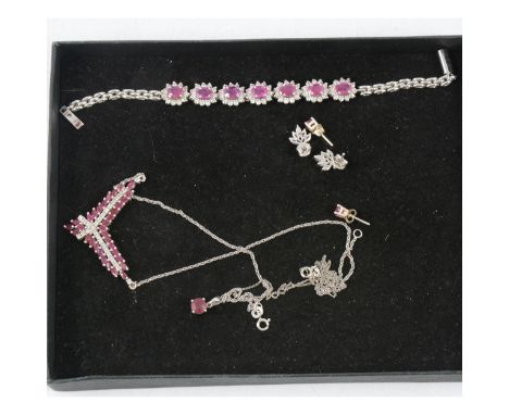 A collection of ruby jewellery set into silver, a V shape necklace, seven cluster bracelet set with oval mixed cut rubies and