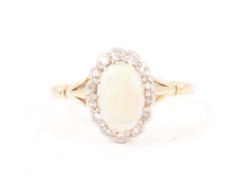 An opal and diamond cluster ring, the oval cabochon cut opal, 9x6.5mm, claw set and surrounded by fourteen old and eight cut 