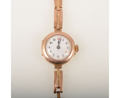 A lady's vintage 9 carat gold wristwatch, 20mm white enamel dial with an arabic numeral chapter ring in a 9 carat yellow gold