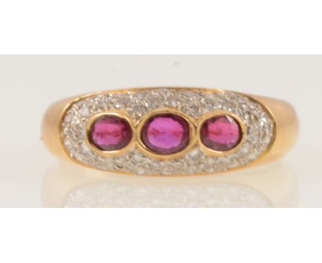 A ruby and diamond dome shape ring, three oval mixed cut rubies and forty-six brilliant cut diamonds pave set in a yellow and