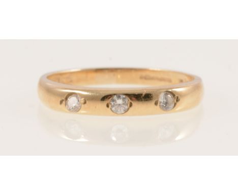 A 9 carat yellow gold band ring gypsy set with three cubic zirconia, ring size K, 1.3gm.