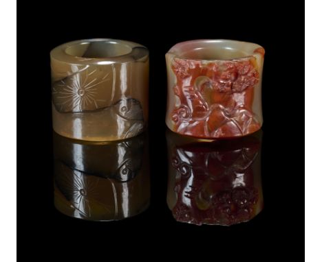 comprising: a ring finely carved in low relief with a fish in a lotus pond, 2.5cm high; and a pale celadon and russet jade ri