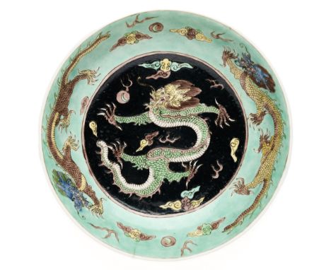 the rounded sides rising from a short tapering foot to an everted rim, enamelled to the interior with a famille noire medalli