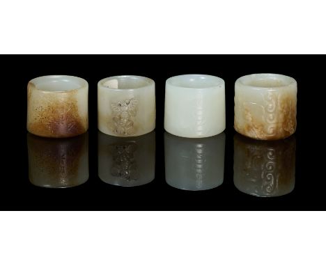comprising: a celadon-white jade ring carved with four fu (happiness) characters, 2.2cm high; a celadon and russet jade ring,