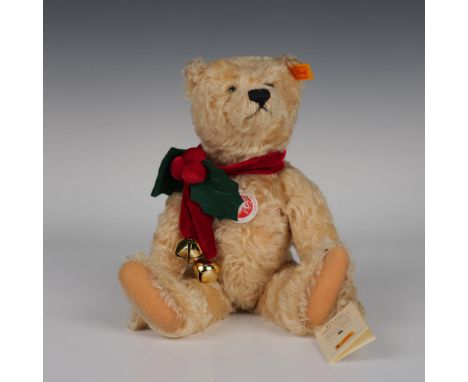 This beautiful articulated bear, crafted from genuine mohair, retains its orange tag in its ear and wears a holly-decorated r