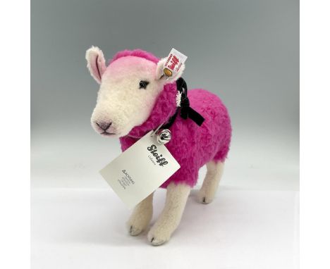 Standing lamb with a bright pink coat and black velvet ribbon around her neck with a bell attached. Steiff tag attached. Dime