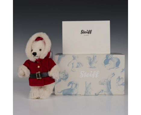 This articulated plush bear, made from genuine mohair, sports a wintery white coat and a red velvet jacket. It includes its r