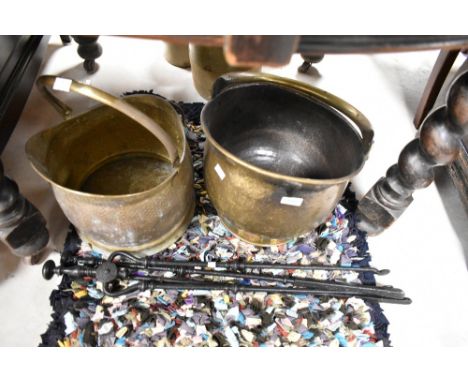 Two brass coal helmets and a selection of fire tools
