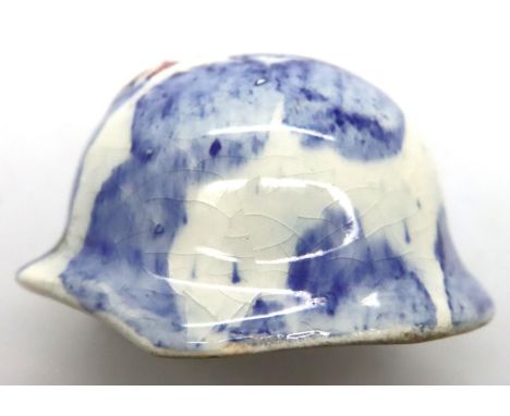 WWII Dutch ceramic miniature German helmet glazed with a raised Swastika decal. H: 35 mm. P&amp;P Group 1 (£14+VAT for the fi