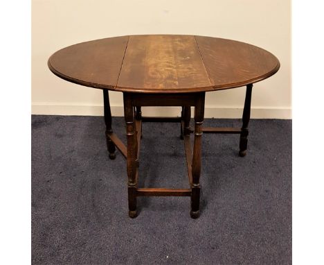 OAK GATE LEG TABLEwith shaped drop flaps, standing on turned supports united by a stretcher, 92cm wide 