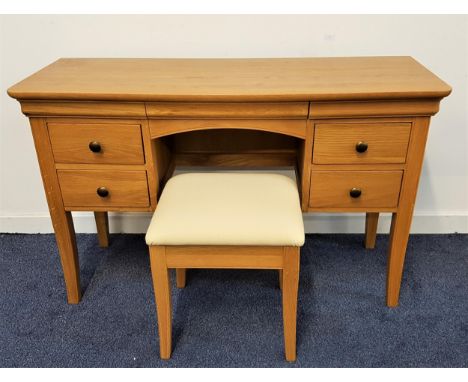 WILLIS & GAMBIER LIGHT OAK DRESSING TABLEwith a moulded top above an arched kneehole flanked by two frieze drawers and two pa