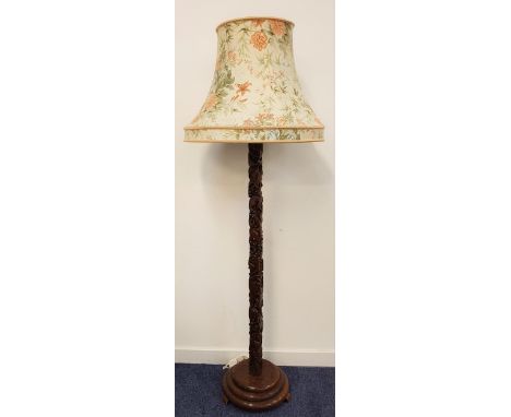 CARVED TEAK STANDARD LAMPraised on a circular stepped base with a carved square column decorated with animals, birds and foli