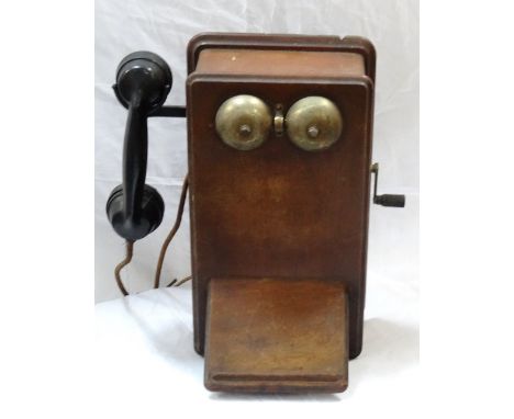 VINTAGE MAHOGANY WALL MOUNTED TELEPHONEwith two central circular brass bells above a slope, with a side mounted bakelite hand