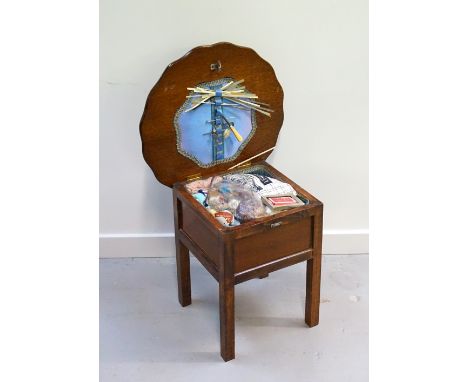 1930s OAK SEWING TABLEwith shaped hinged top, raised on straight legs, containing a selection of vintage sewing/knitting mate