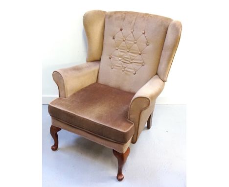 WING BACK ARMCHAIRthe button back above shaped arms, with a loose shaped seat cushion, standing on front cabriole supports 