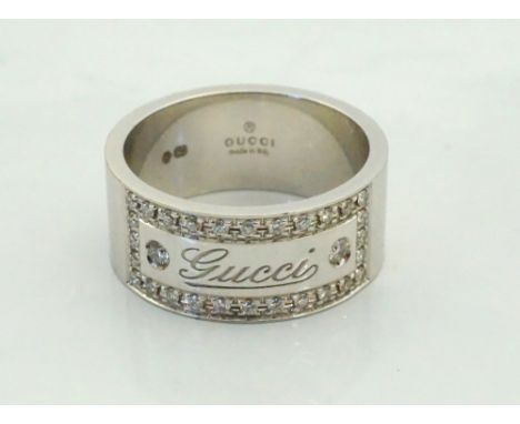 GUCCI EIGHTEEN CARAT WHITE GOLD AND DIAMOND RINGthe Gucci engraved panel in diamond surround, ring size Q-R, approximately 12