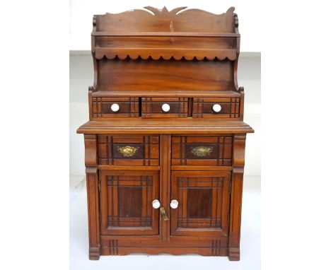 EARLY 20th CENTURY MAHOGANY COLLECTORS CABINETthe shaped carved top above an open shelf with shaped sides, with three central