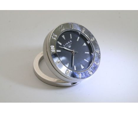A Links London travel alarm clock with white batons and quarterly pointers marked on a black face, the bezel presenting arabi