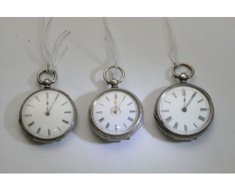 Three small silver cased button wind pocket watches, all having decorative backs and roman numerals