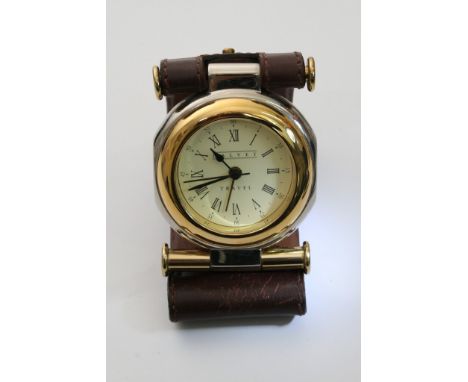 A Dalvey travel alarm clock with both roman and arabic numerals, set in a brown leather case