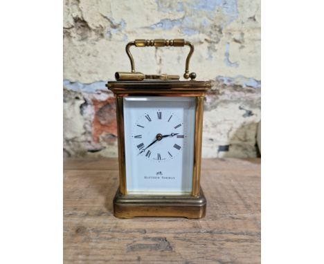 A brass carriage clock by Mathew Norman. 