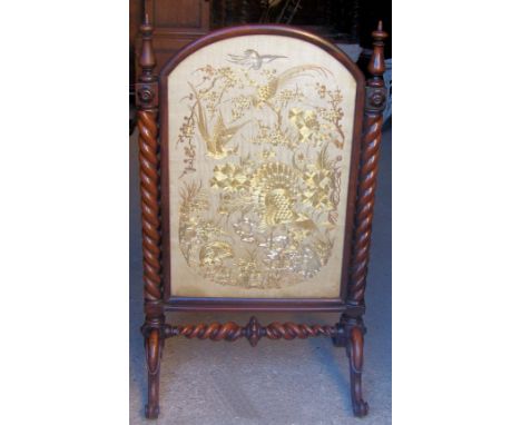 A Victorian oak Firescreen, the arch panel with embroidered decoration, with spiral turned pilasters, cross stretcher and spl
