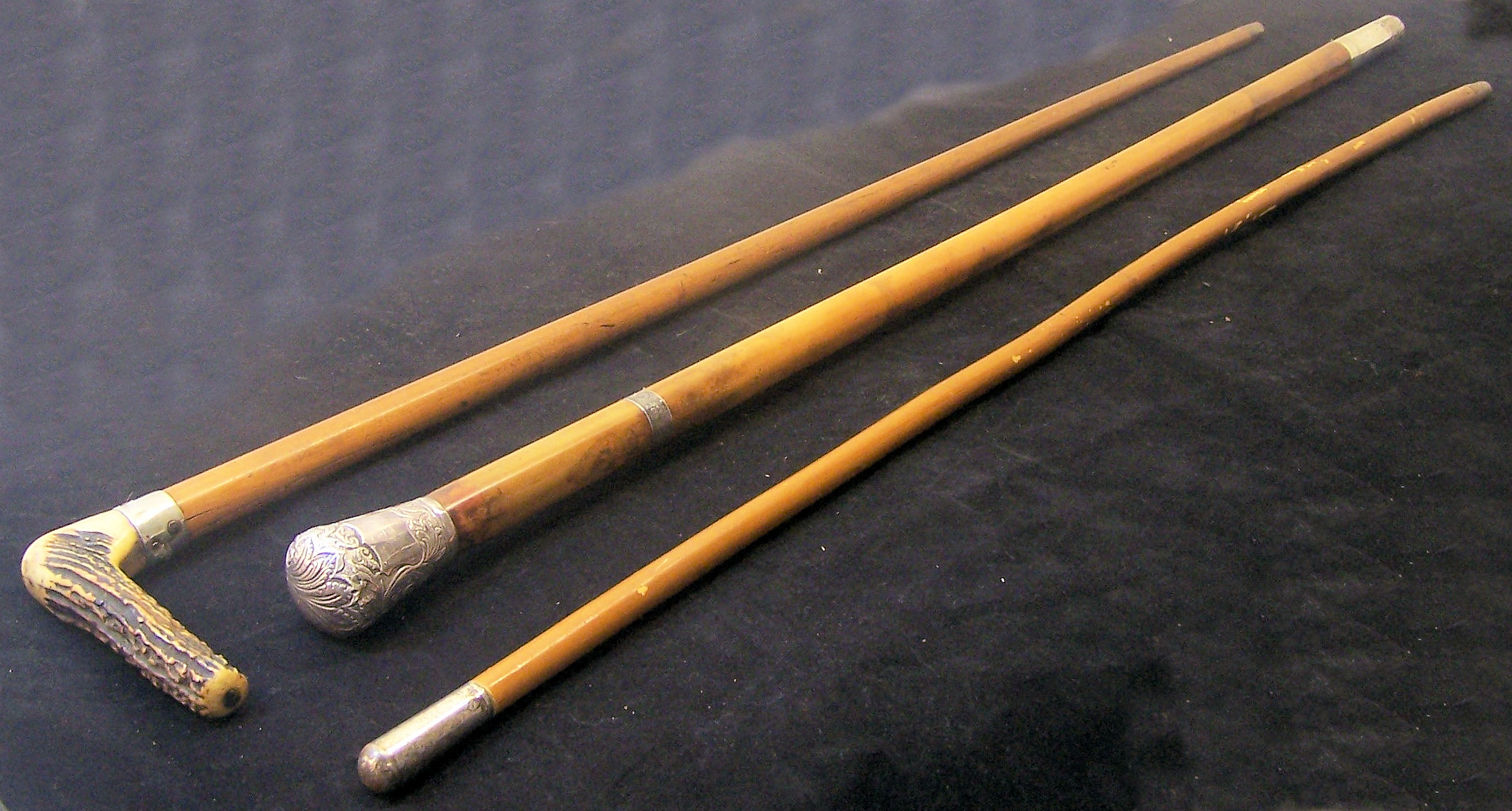 A Malacca Cane with silvered metal mounts, a Military Swagger Stick