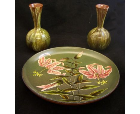 A Victorian Linthorpe Pottery circular shallow Dish painted with star gazer lilies, on a dark green ground and with the monog