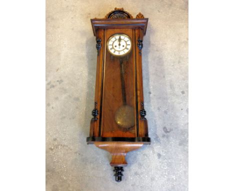 A Vienna Wall Clock with white dial and twin weight driven movement, in architectural style walnut case, 3' 7" (110cms) high.